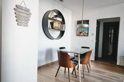 a dining room with a table and chairs and a mirror at 2 Pieces bourgeois centre de Cannes 4 couchages une pépite in Cannes