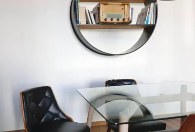 a mirror on a wall with a glass table and a chair at 2 Pieces bourgeois centre de Cannes 4 couchages une pépite in Cannes