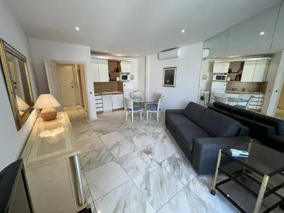 a living room with a couch and a table at 540 Cannes La Croisette - Joli studio au calme coté jardin in Cannes