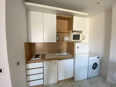 a small kitchen with a washer and a microwave at 540 Cannes La Croisette - Joli studio au calme coté jardin in Cannes