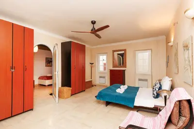 a bedroom with a bed and a ceiling fan at Una Rosa Blu YourHostHelper in Cannes