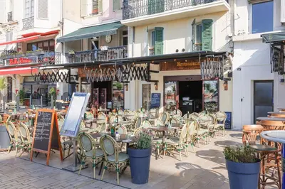 a group of tables and chairs on a city street at Una Rosa Blu YourHostHelper in Cannes