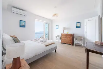 a white bedroom with a bed and a desk at Cannes Suquet Sea View & Beach Access in Cannes