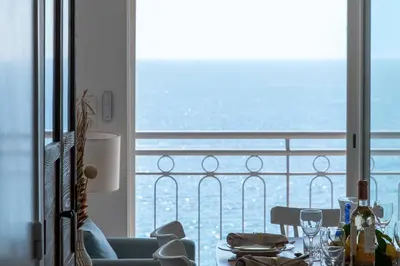 a dining room with a view of the ocean from a balcony at Cannes Suquet Sea View & Beach Access in Cannes