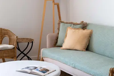 a living room with a couch with a pillow and a table at Cannes Suquet Sea View & Beach Access in Cannes