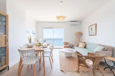 a living room with a table and a couch at Cannes Suquet Sea View & Beach Access in Cannes