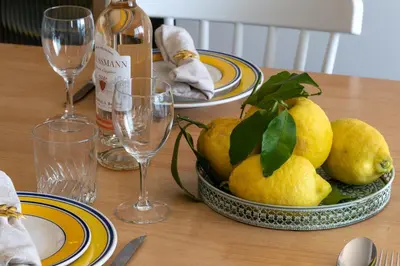 a table with a bowl of pears and wine glasses at Cannes Suquet Sea View & Beach Access in Cannes