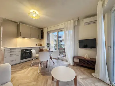 a kitchen and living room with a table and chairs at Mont Joli in Le Cannet
