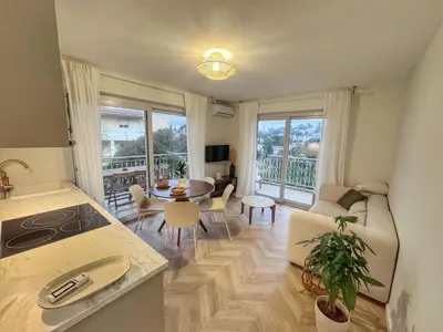 a kitchen and living room with a table and a couch at Mont Joli in Le Cannet