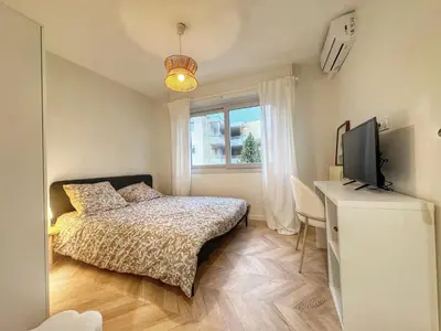 a bedroom with a bed and a tv and a window at Mont Joli in Le Cannet