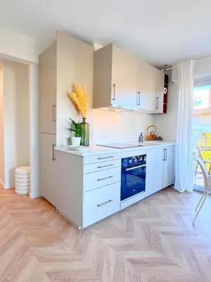 a kitchen with white cabinets and a blue appliance at Mont Joli in Le Cannet