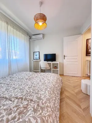 a bedroom with a large bed and a desk at Mont Joli in Le Cannet