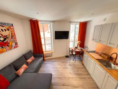 a living room with a couch and a kitchen at Casa Bisou Cannes - BOHEME in Cannes