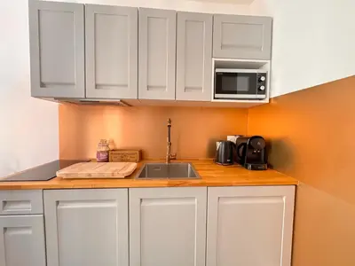 a kitchen with white cabinets and a sink and a microwave at Casa Bisou Cannes - BOHEME in Cannes