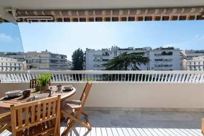 a balcony with a table and chairs on a roof at Spacious 1-Br Apartment with Terrace Heart of Cannes in Cannes
