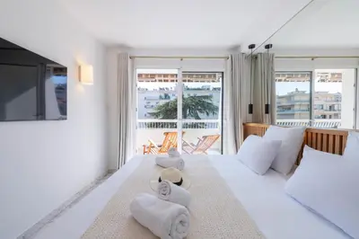 a bedroom with a large white bed with towels on it at Spacious 1-Br Apartment with Terrace Heart of Cannes in Cannes
