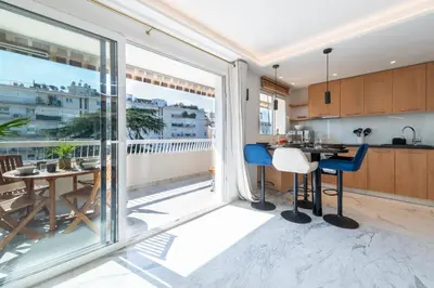 a kitchen with a large glass door leading to a balcony at Spacious 1-Br Apartment with Terrace Heart of Cannes in Cannes