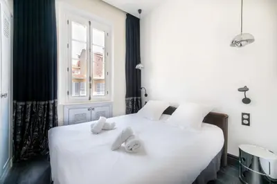 a bedroom with a large white bed with towels on it at Prestige & Comfort Facing the Palais des Festivals in Cannes