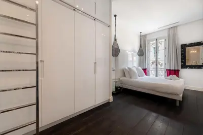 a white bedroom with a couch and a window at Prestige & Comfort Facing the Palais des Festivals in Cannes