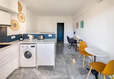 a kitchen with a sink and a blue tiled wall at L'Astrolabe - Studio - refurbished - seaside in Cannes