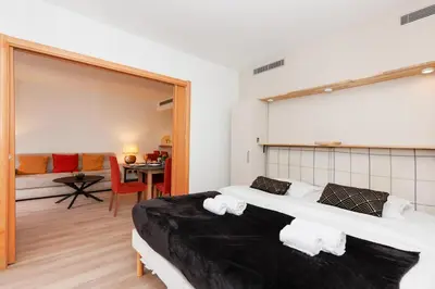 a bedroom with two beds and a living room at Pavillon Riviera YourHostHelper in Cannes