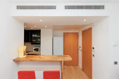 a kitchen with a wooden counter top and red accents at Pavillon Riviera YourHostHelper in Cannes