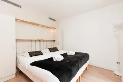a bedroom with two beds with black and white sheets at Pavillon Riviera YourHostHelper in Cannes