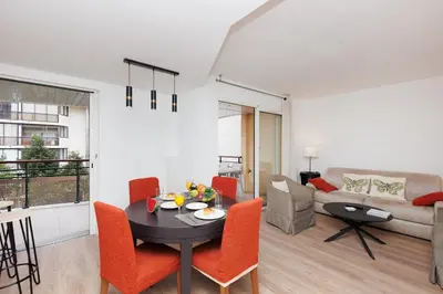 a living room with a table and chairs and a couch at Pavillon Riviera YourHostHelper in Cannes