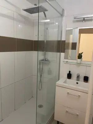 a bathroom with a glass shower and a sink at BY NEPTUNE - La Palme Azur Beach view in Cannes