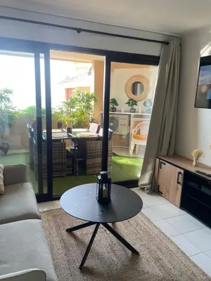 a living room with a couch and a table at BY NEPTUNE - La Palme Azur Beach view in Cannes