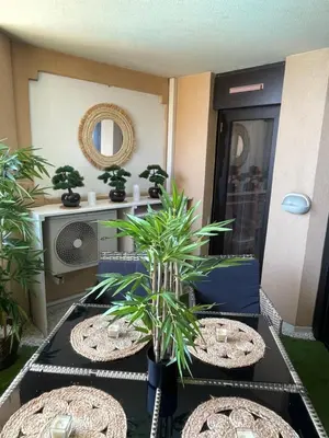 a living room with two tables and two potted plants at BY NEPTUNE - La Palme Azur Beach view in Cannes