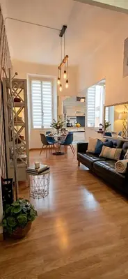 a living room with a black couch and a table at Centre Carré d'or 3 chambres in Cannes