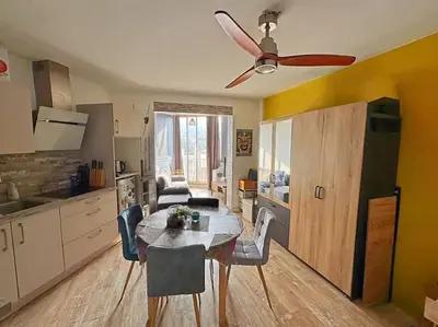 a kitchen and dining room with a table and a ceiling fan at Charmant Studio - Centre Cannes in Cannes