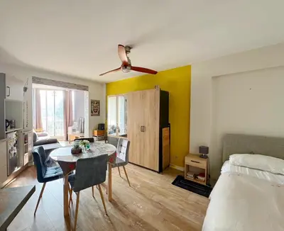 a room with a bed and a table and a bedroom at Charmant Studio - Centre Cannes in Cannes