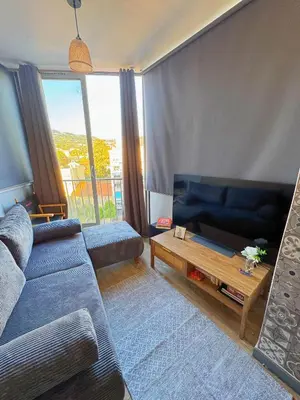 a living room with a couch and a table at Charmant Studio - Centre Cannes in Cannes