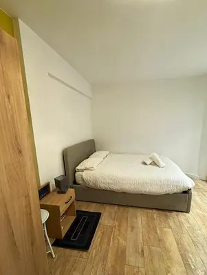 a small bedroom with a bed and a wooden floor at Charmant Studio - Centre Cannes in Cannes