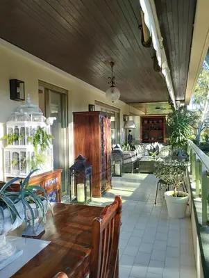 a large porch with a wooden table and chairs at La Californie Views II in Cannes