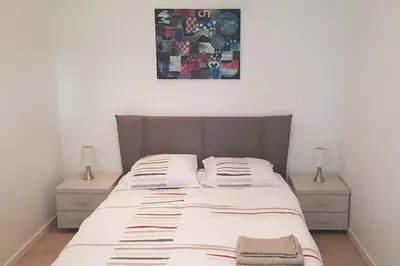 a bed in a bedroom with two nightstands and a picture above it at Appartement 2 pièces cannes in Cannes