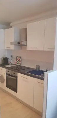 a kitchen with white cabinets and a stove top oven at Appartement 2 pièces cannes in Cannes