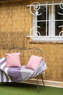 a bench with two pink pillows sitting in front of a building at Apartment in Cannes in Cannes
