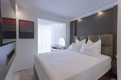 a bedroom with a large white bed and a desk at Croisette Star - Bd Croisette in Cannes