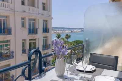 a table with a vase of flowers on a balcony at Croisette Star - Bd Croisette in Cannes