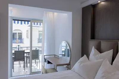 a bedroom with a bed and a table and a balcony at Croisette Star - Bd Croisette in Cannes
