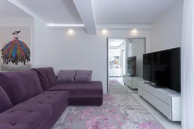 a living room with a purple couch and a flat screen tv at Croisette Star - Bd Croisette in Cannes