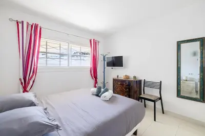 a bedroom with a bed and a chair and a window at Latour Maubourg 20 by Halldis in Cannes