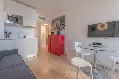 a living room with a table and a red refrigerator at Cannes Serenity – Elegant Stay in Central Cannes in Cannes