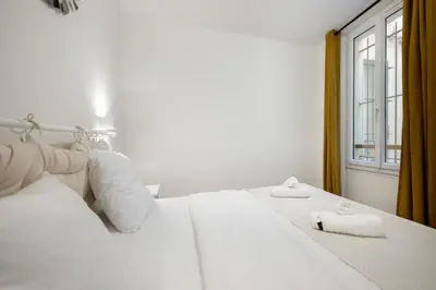 a white bed with white pillows and a window at Elegant 2P Rue Meynadier 350 m Palais & beaches in Cannes