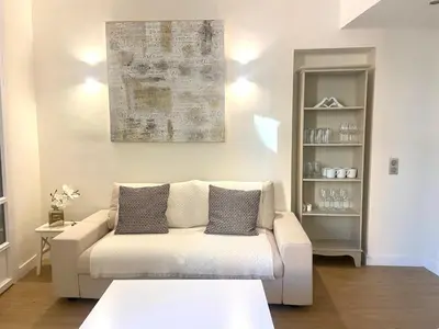 a living room with a white couch and a table at Elegant 2P Rue Meynadier 350 m Palais & beaches in Cannes