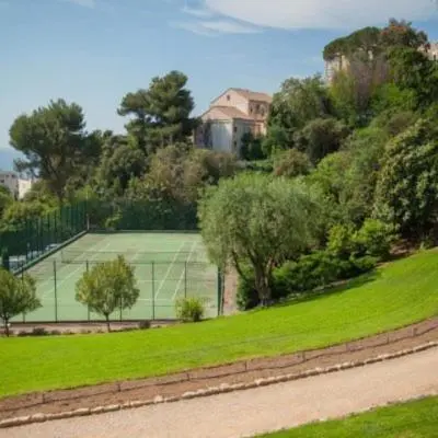 a tennis court in the middle of a green field at Les Oliviers 3, Domaine de Pierre Longue in Cannes