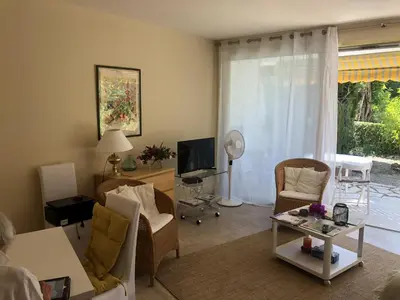 a living room with a couch and chairs and a tv at Les Oliviers 3, Domaine de Pierre Longue in Cannes
